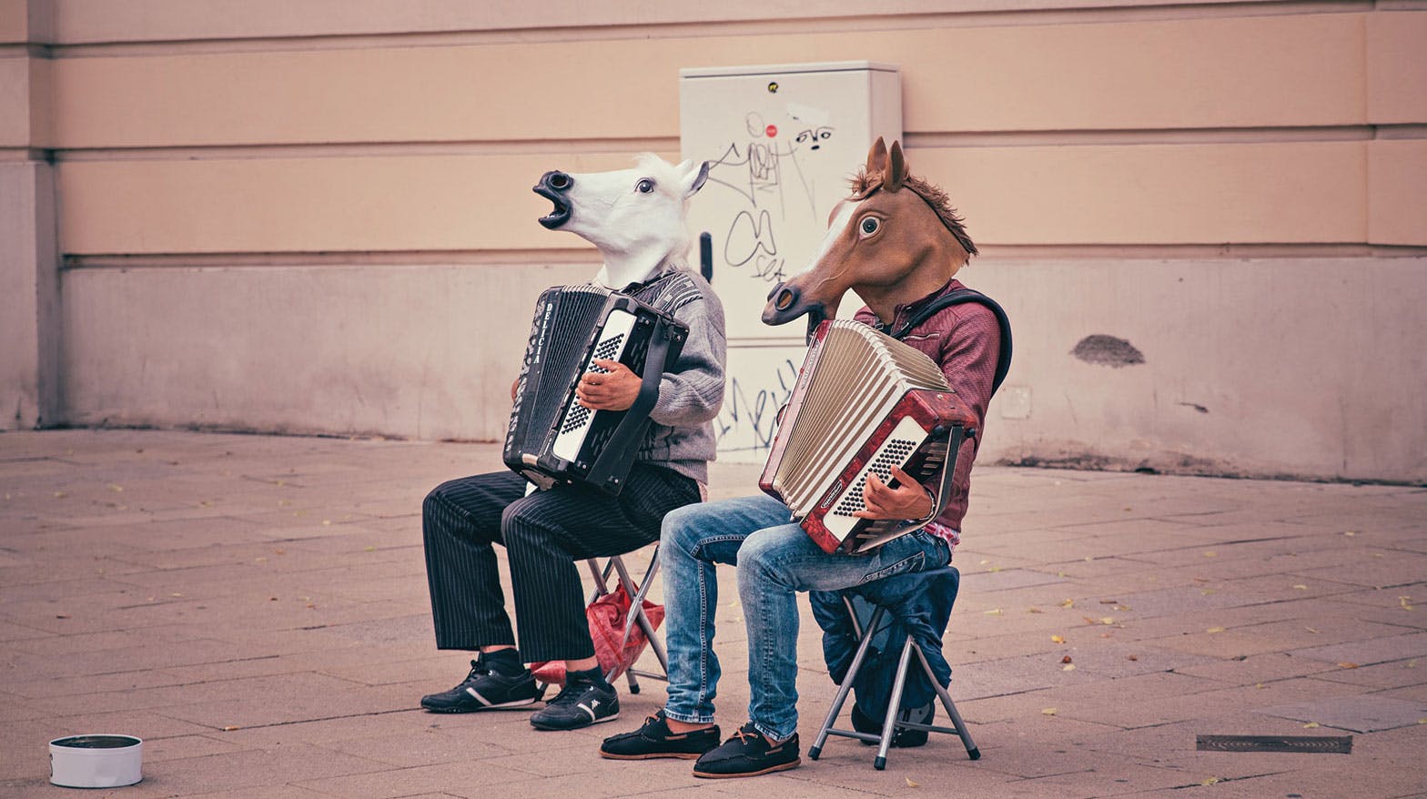 Two men playing accordions wearing horse masks